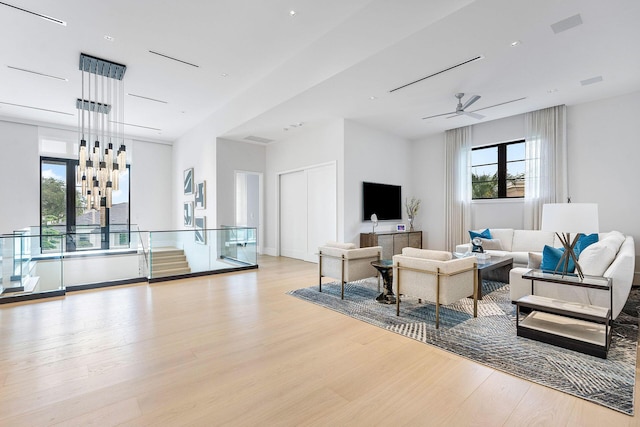 living room with ceiling fan, plenty of natural light, and light hardwood / wood-style floors