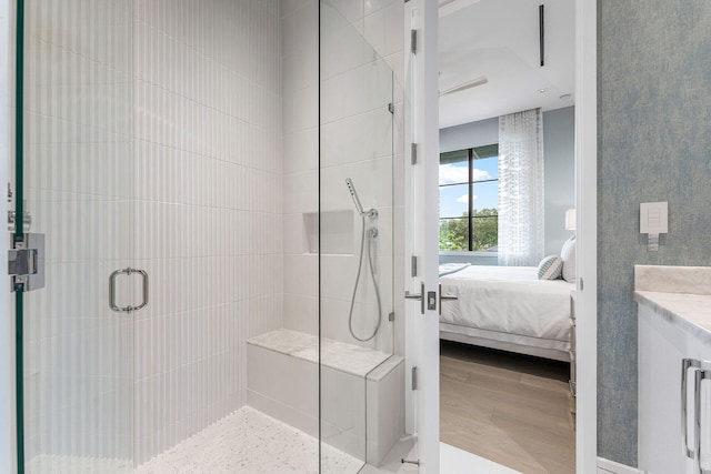 bathroom featuring walk in shower, hardwood / wood-style floors, and vanity