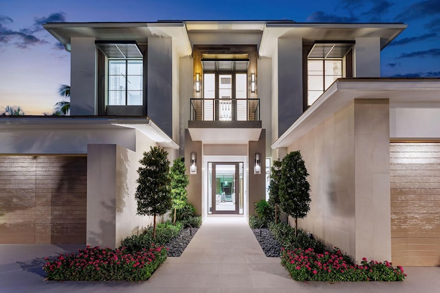 exterior entry at dusk with a balcony