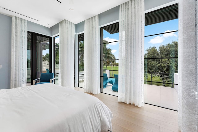 bedroom featuring access to exterior and light hardwood / wood-style flooring