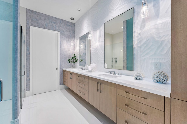 bathroom featuring a shower with door and vanity