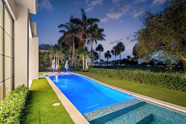 pool at dusk with a yard