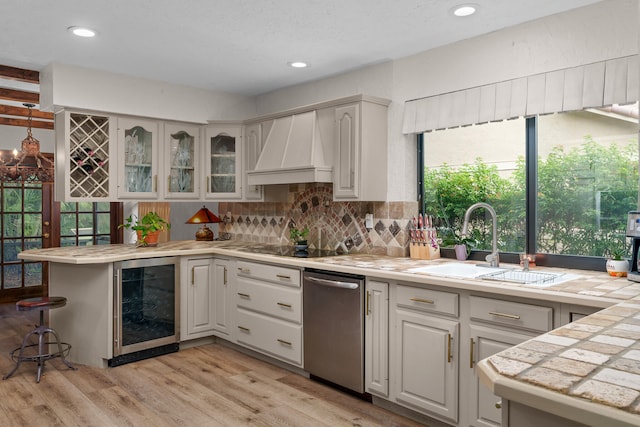 kitchen featuring custom range hood, beverage cooler, a healthy amount of sunlight, and light hardwood / wood-style floors