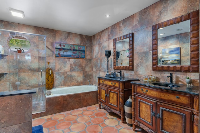 bathroom featuring tile walls, shower with separate bathtub, and vanity