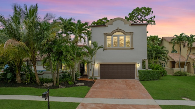 mediterranean / spanish house with a yard and a garage