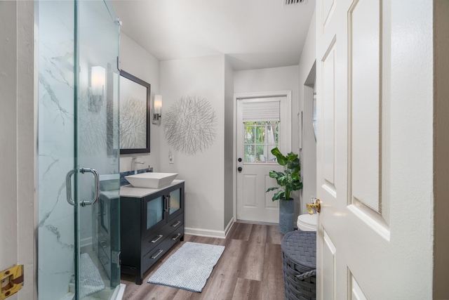 bathroom featuring vanity, toilet, wood-type flooring, and walk in shower