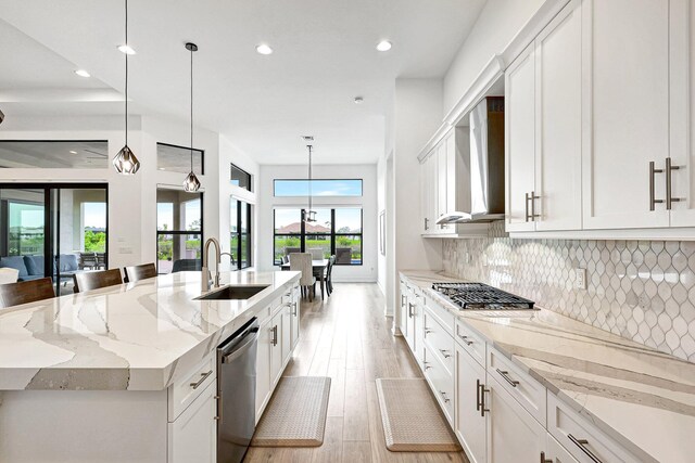 kitchen featuring light hardwood / wood-style flooring, stainless steel appliances, light stone counters, and white cabinetry