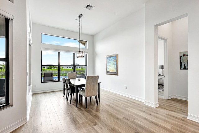 dining space featuring light wood-type flooring and a chandelier