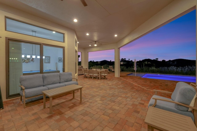 patio terrace at dusk featuring ceiling fan and an outdoor hangout area