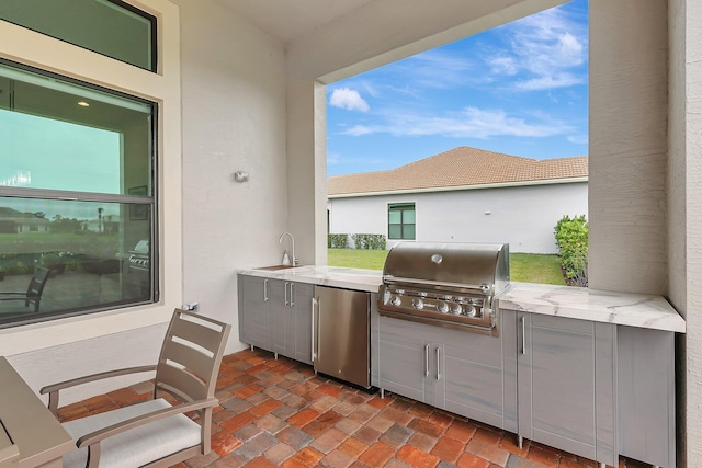 view of patio featuring exterior kitchen, sink, and a grill