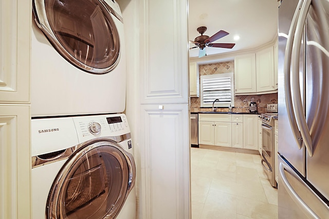 washroom featuring sink, ceiling fan, and stacked washer / dryer