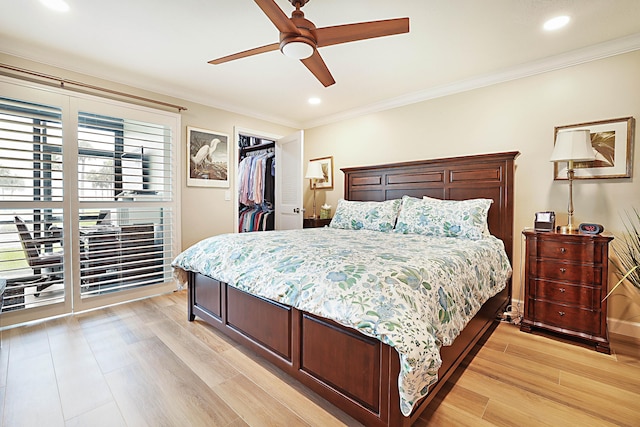 bedroom featuring light hardwood / wood-style flooring, a spacious closet, ceiling fan, crown molding, and a closet