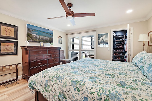 bedroom featuring crown molding, light hardwood / wood-style flooring, and ceiling fan