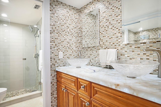 bathroom featuring backsplash, vanity, tile walls, and a tile shower