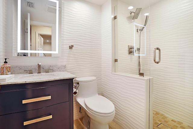 bathroom featuring vanity, an enclosed shower, and toilet