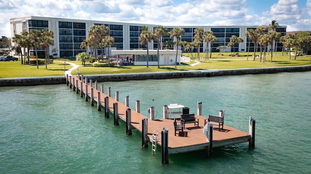 view of dock featuring a water view and a yard