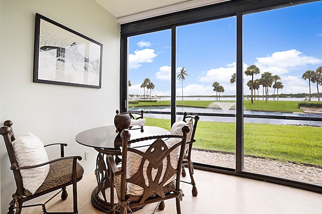 sunroom featuring a water view