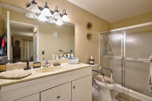 bathroom featuring tile patterned flooring, vanity, toilet, and a shower with door