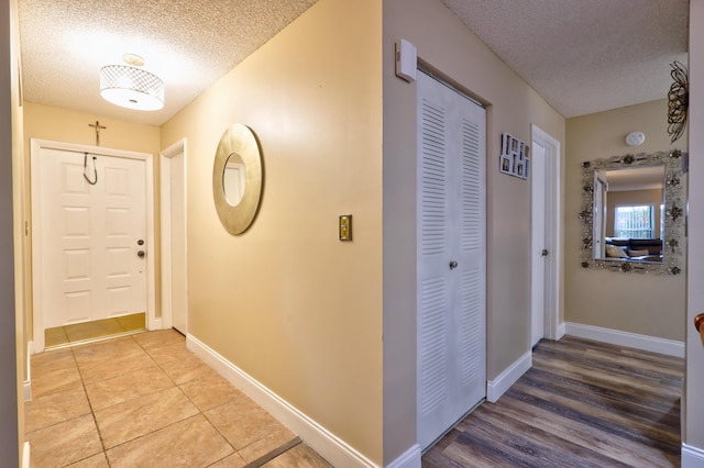 hallway with tile patterned floors and a textured ceiling