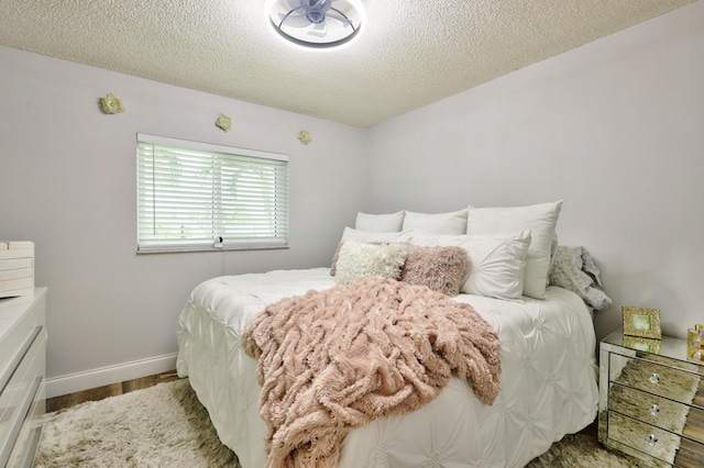 bedroom featuring a textured ceiling and hardwood / wood-style flooring