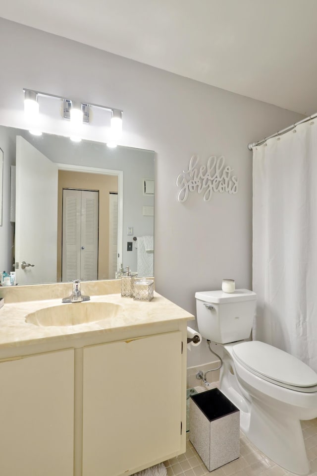 bathroom with tile patterned flooring, vanity, and toilet