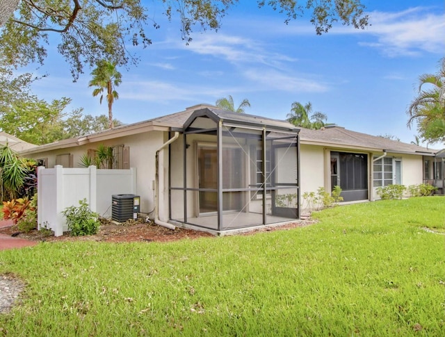 back of house with a yard, cooling unit, and a lanai