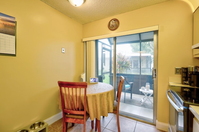 dining area with light tile patterned floors and a textured ceiling