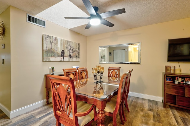 dining space with a textured ceiling, dark hardwood / wood-style flooring, and ceiling fan