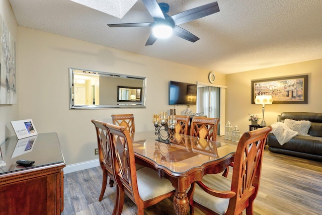 dining space featuring ceiling fan, a textured ceiling, and light hardwood / wood-style flooring