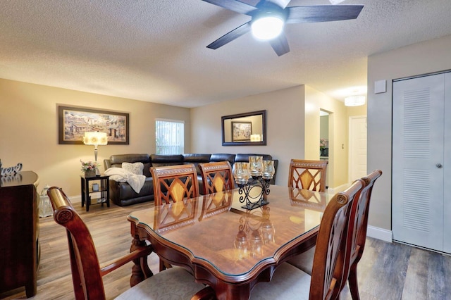 dining space with ceiling fan, a textured ceiling, and hardwood / wood-style flooring