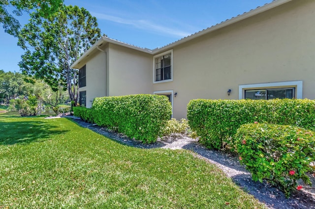 view of side of home with a yard