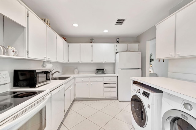 kitchen featuring sink, white appliances, light tile patterned floors, and white cabinets