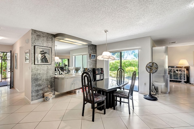 dining room with a textured ceiling and light tile patterned floors