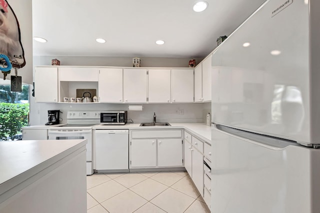 kitchen with sink, white appliances, white cabinetry, and light tile patterned floors