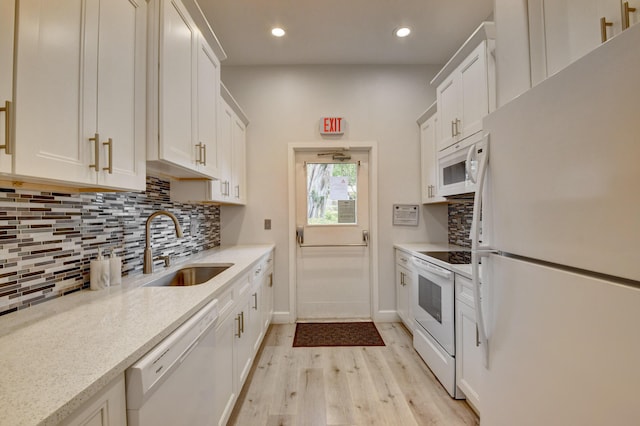 kitchen with sink, white cabinetry, white appliances, backsplash, and light stone countertops