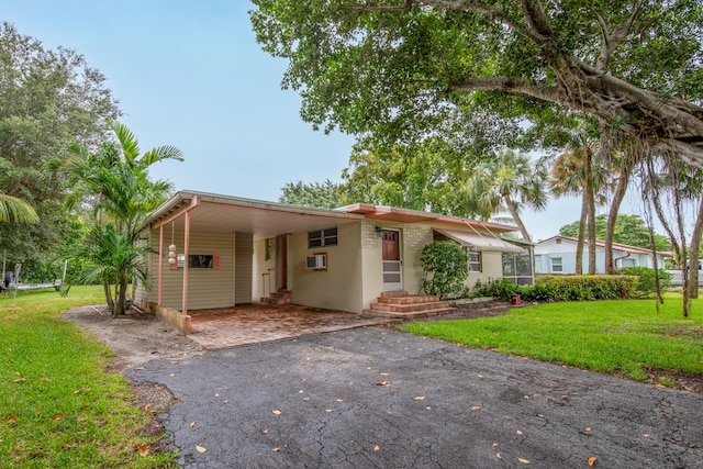 view of front of house featuring a carport and a front yard