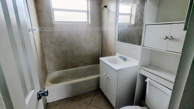 full bathroom featuring tiled shower / bath combo, vanity, tile patterned flooring, and toilet