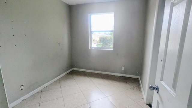 spare room with baseboards and light tile patterned floors