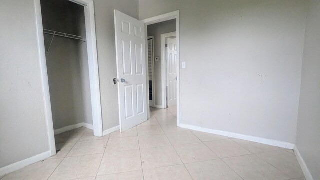 unfurnished bedroom featuring a closet and light tile patterned floors