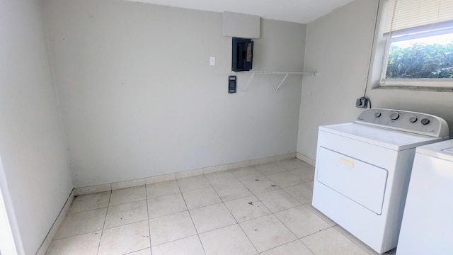 laundry room with electric panel, washer and dryer, and light tile patterned floors