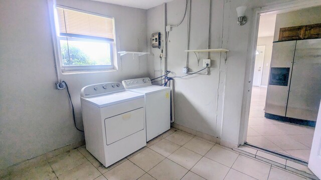 laundry room featuring light tile patterned floors and washing machine and clothes dryer