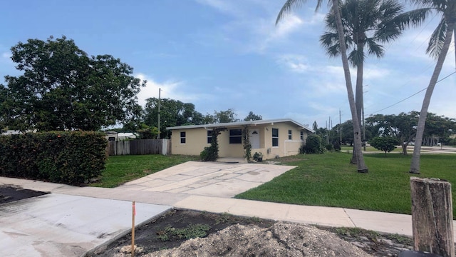 view of front of house with a front yard, fence, and stucco siding