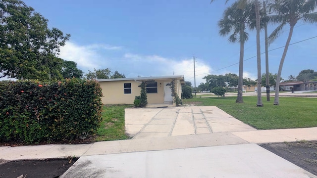 view of front of home featuring stucco siding and a front yard