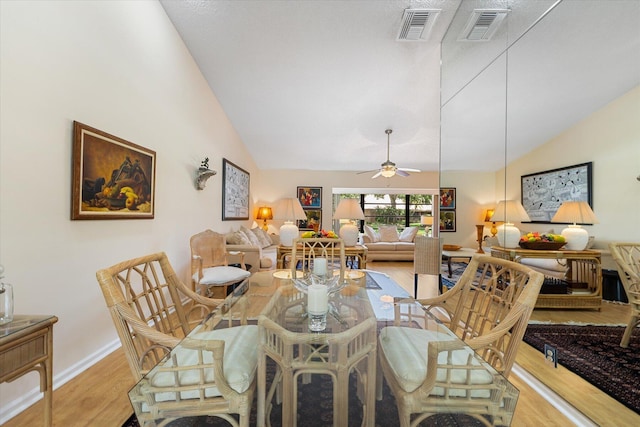 dining area with ceiling fan, light wood-type flooring, and lofted ceiling