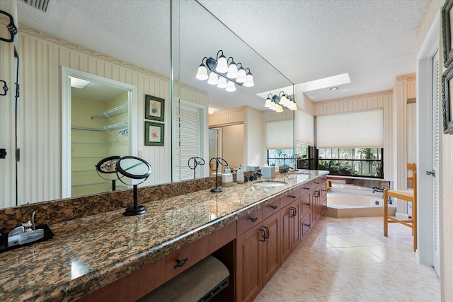 bathroom with tile patterned floors, vanity, and a textured ceiling