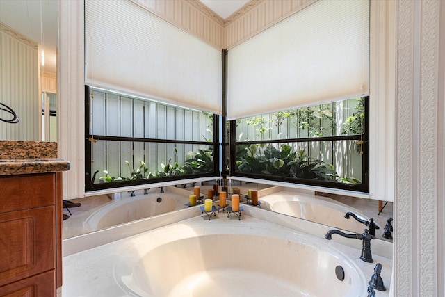 bathroom featuring vanity and a bath