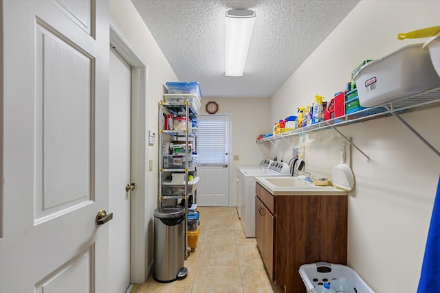 laundry room featuring cabinets, light tile patterned flooring, washer and dryer, and a textured ceiling