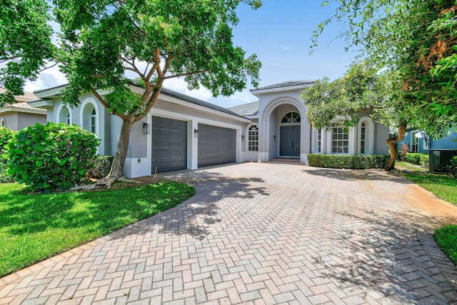 view of front of home with a garage and a front lawn