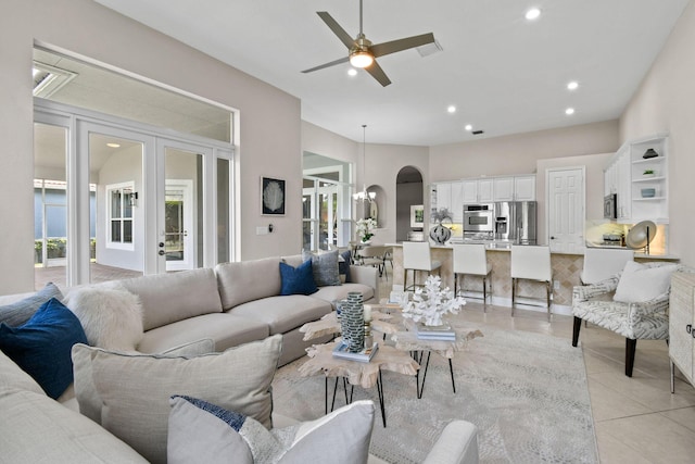 living room with plenty of natural light, french doors, ceiling fan, and light tile patterned flooring