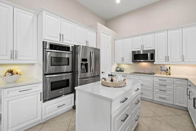 kitchen with stainless steel appliances, white cabinetry, and light tile patterned floors